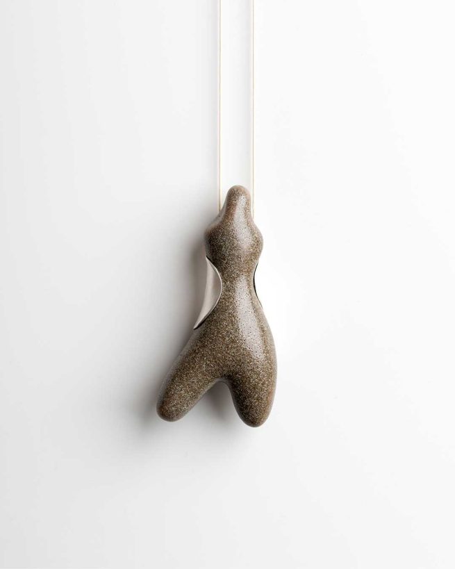 Joieria contemporània. Penjoll de porcellana i plata inspirat amb les pedres del mar. Dissenyat i creat per la joiera Marta Ortí. Terrassa, Barcelona.