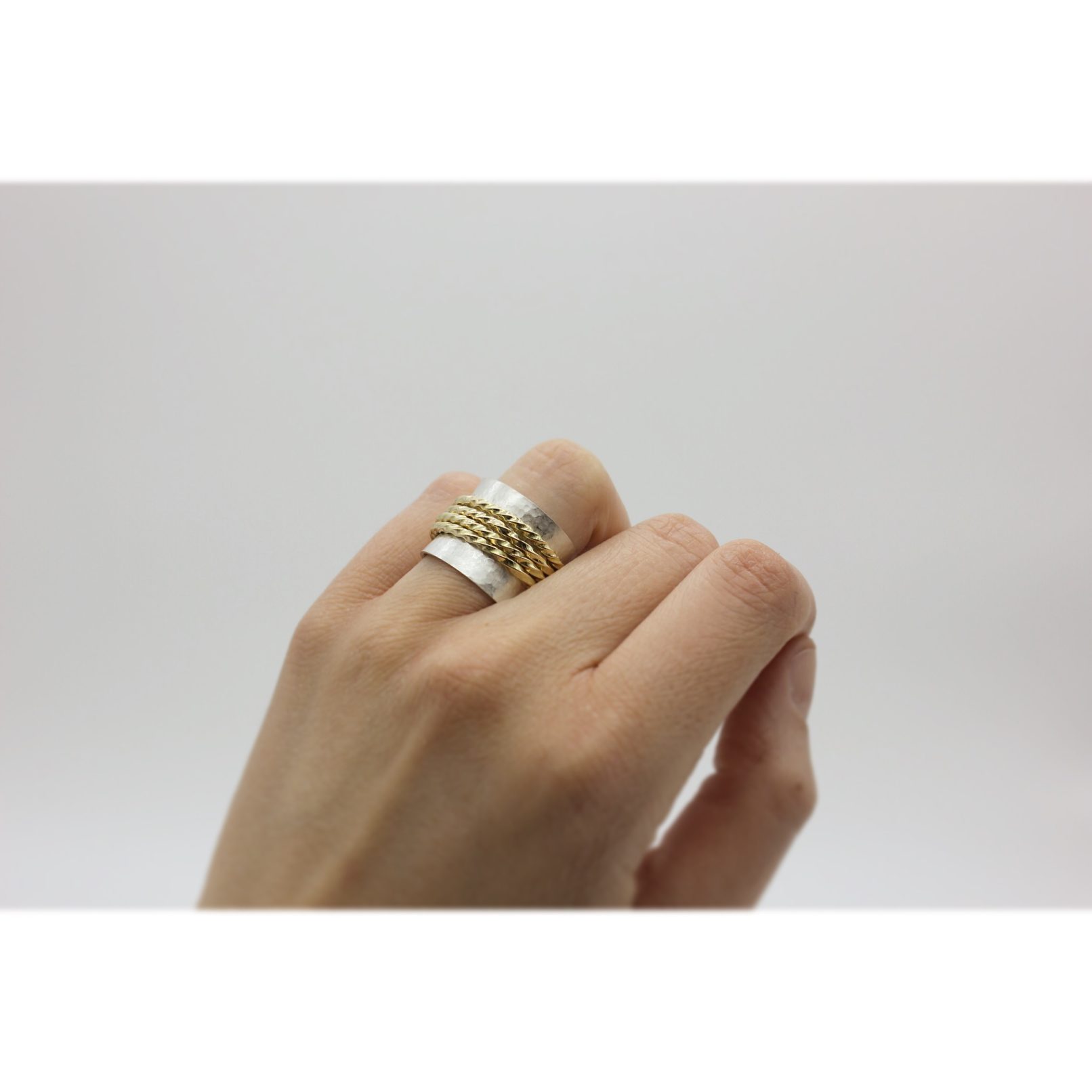 Joieria contemporània. Anell d’or reciclat i plata. La materia de l'or es composa per les alicances dels seus pares i avis. Les 4 anelles d’or simbolitzen ells quatre. Dissenyat i creat per la joiera Marta Ortí. Terrassa, Barcelona.